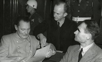 Photograph of Hermann Goering and Rudolph Hess reviewing a document at the trial